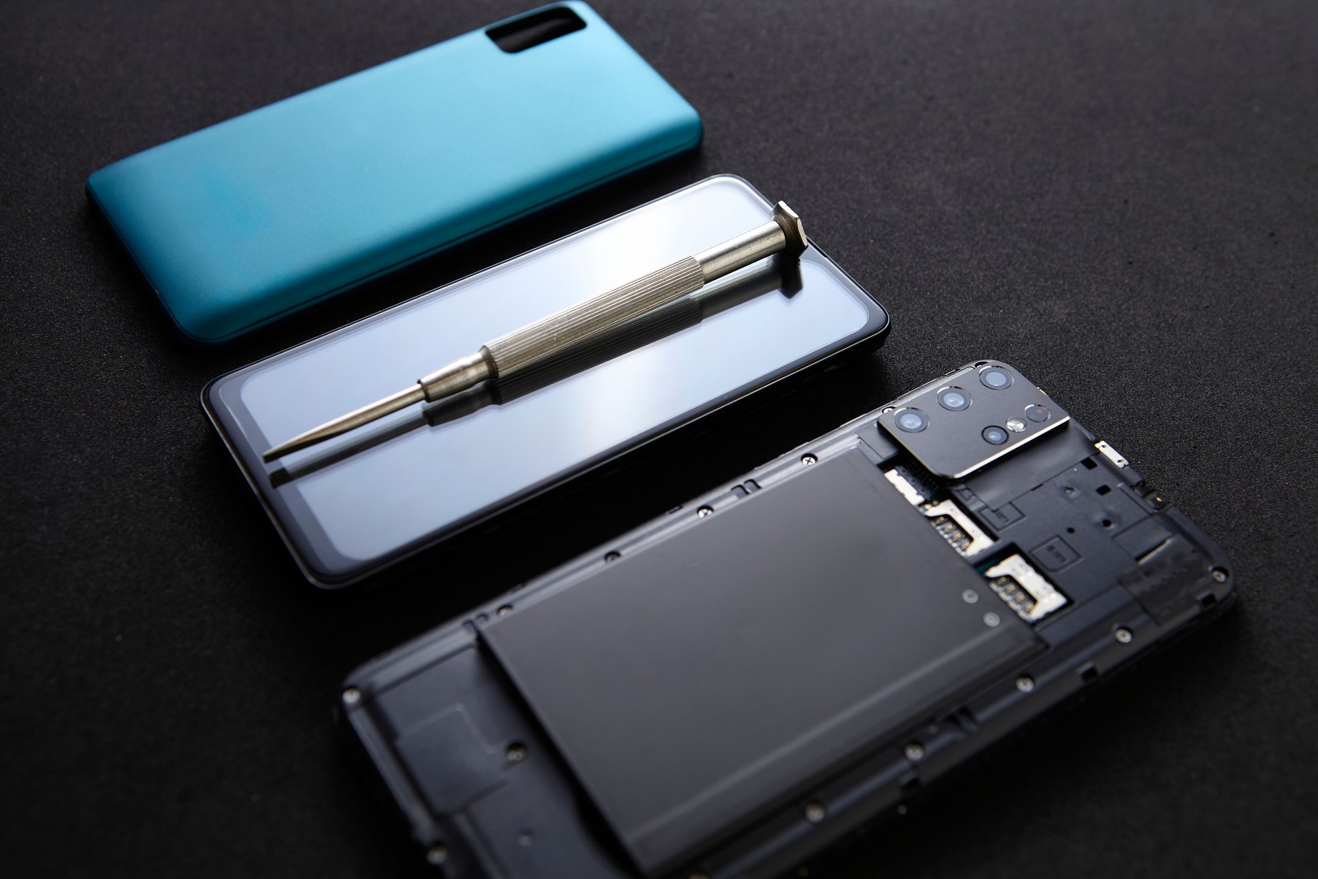 Smartphone repair tools and parts set neatly arranged on black surface