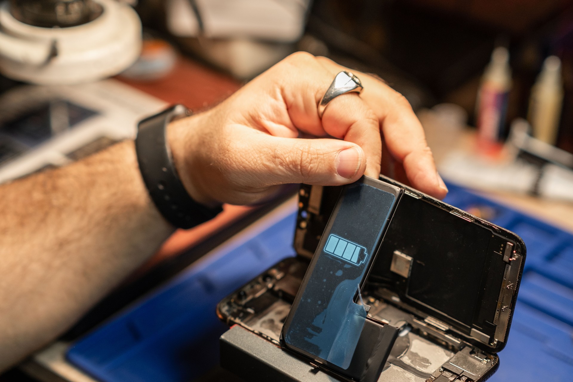 Expert Technician Performing Smartphone Battery Repair In A Workshop During Daytime
